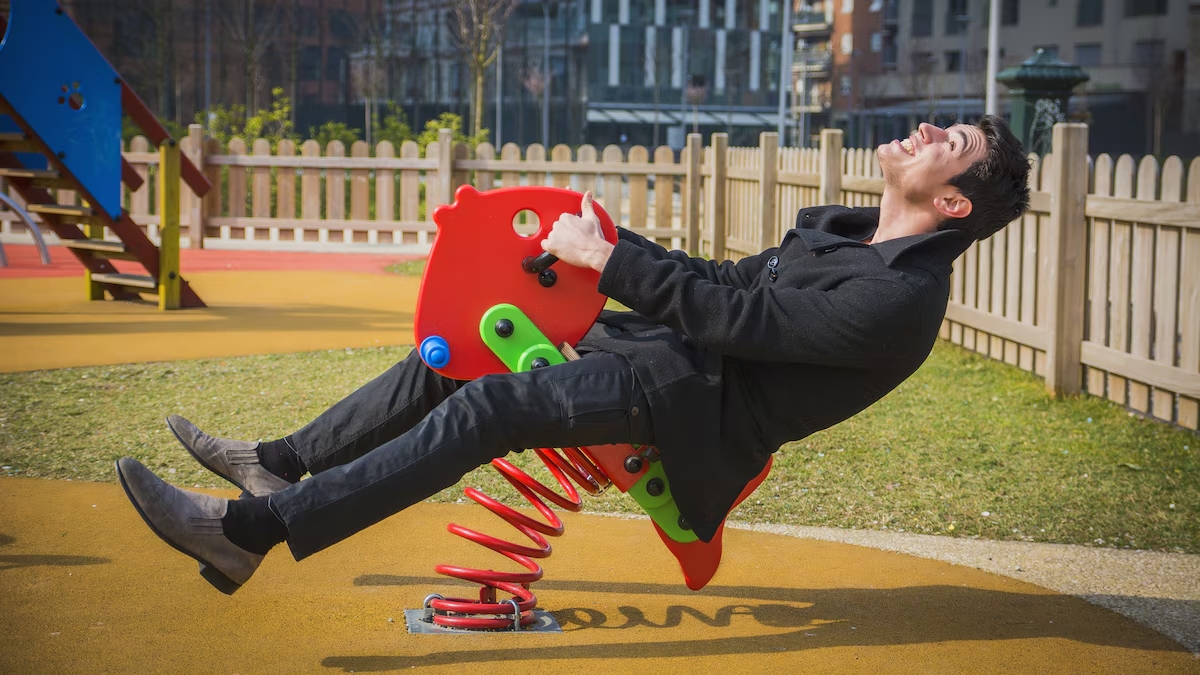 Hombre blanco de traje jugando en un parque de diversiones