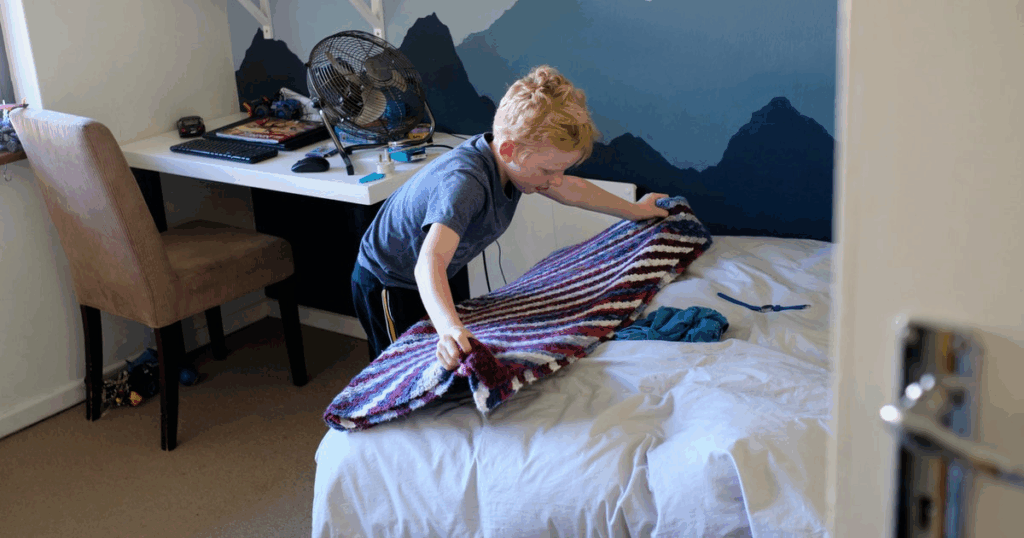 Niño ordenando su cuarto como parte de la disciplina positiva